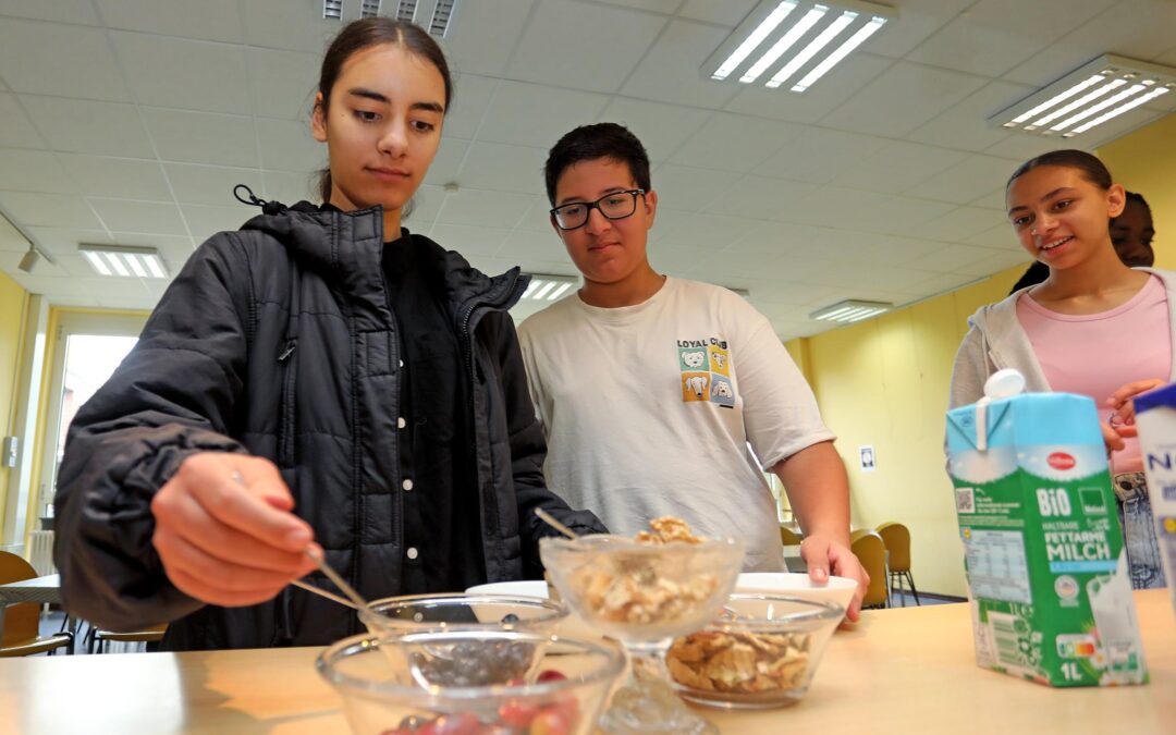 Alisha packt sich noch ein paar frische Toppings auf Müsli: Früchte der Saison und Nüsse.