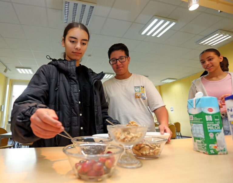 Alisha packt sich noch ein paar frische Toppings auf Müsli: Früchte der Saison und Nüsse.
